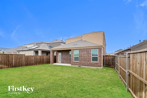 A house with a fence and a grassy yard.