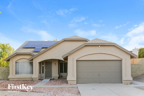 a home with solar panels on the roof and a garage