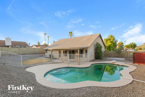 a pool in front of a house with a pool