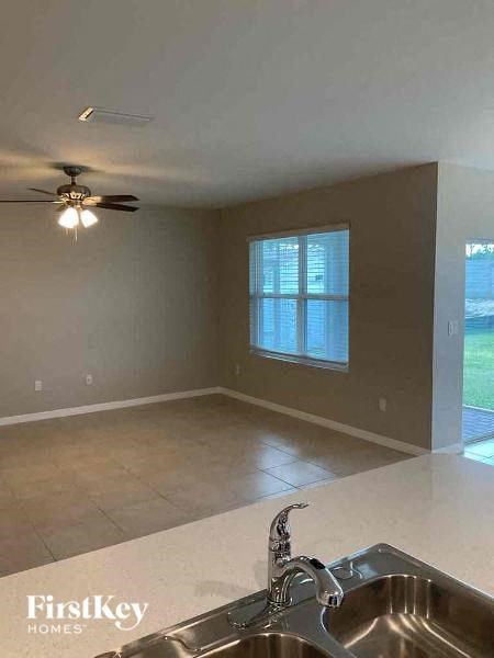 A kitchen with a sink and a ceiling fan.