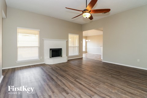a living room with a fireplace and a ceiling fan