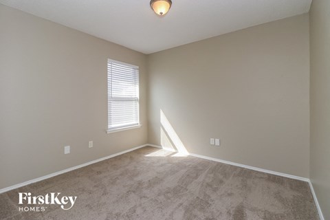 a bedroom with a carpeted floor and a window