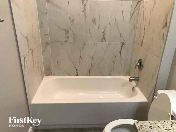 a bathroom with a toilet and a bath tub