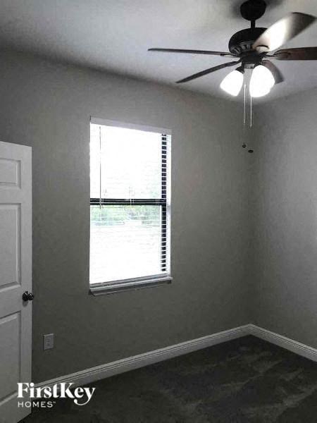 an empty room with a ceiling fan and a window