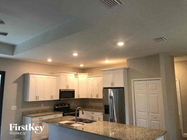 a kitchen with white cabinets and a granite counter top