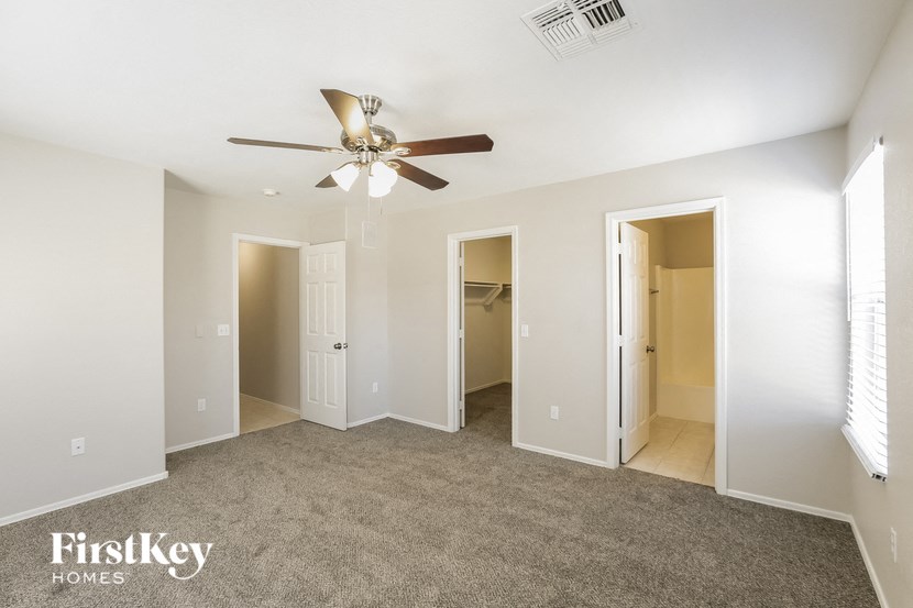 a living room with carpet and a ceiling fan