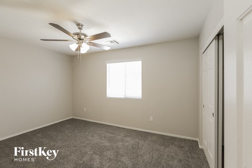 a bedroom with a ceiling fan and a closet