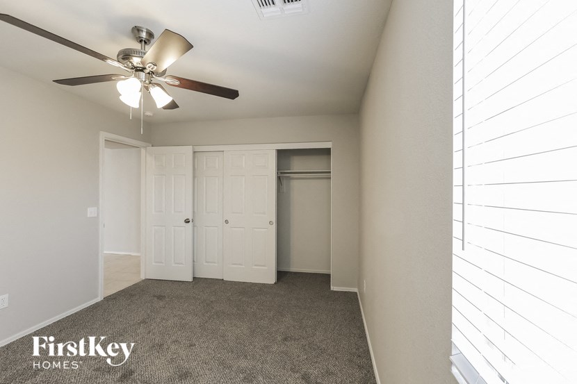 a bedroom with a ceiling fan and a closet