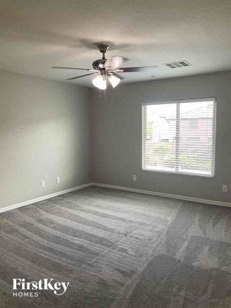 an empty room with a ceiling fan and a window