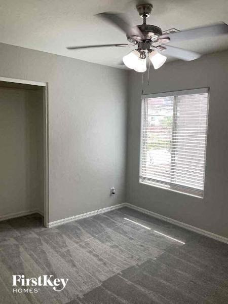 an empty room with a ceiling fan and a window