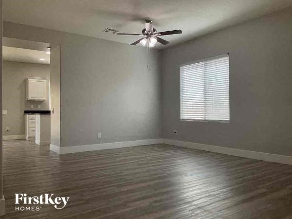 an empty living room with a ceiling fan