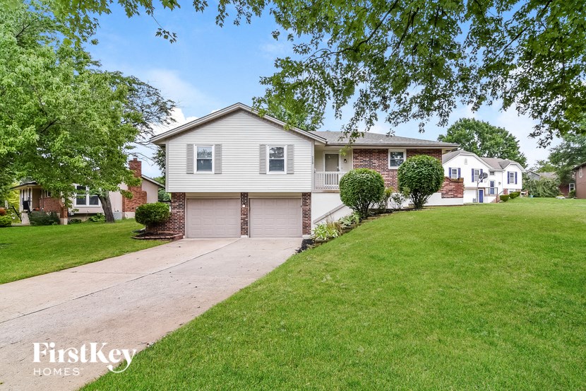 a white house with a lawn and a driveway