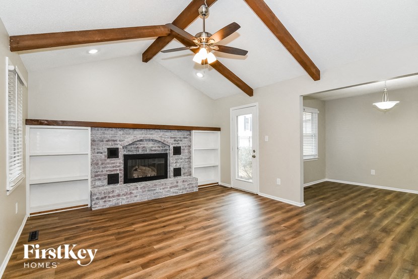 a living room with a fireplace and a ceiling fan