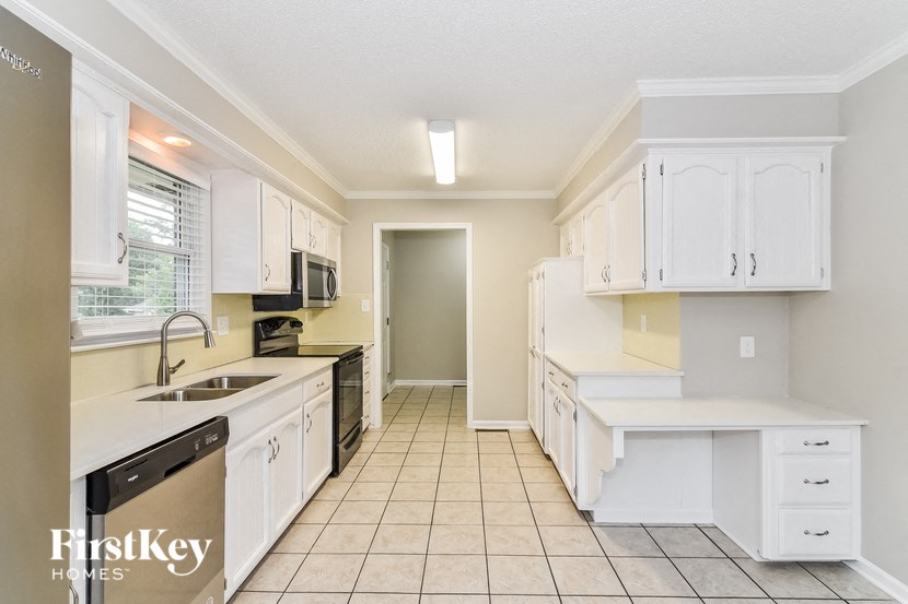 a large kitchen with white cabinets and a sink