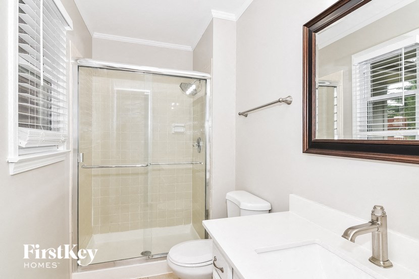 a bathroom with a shower toilet and sink and a mirror