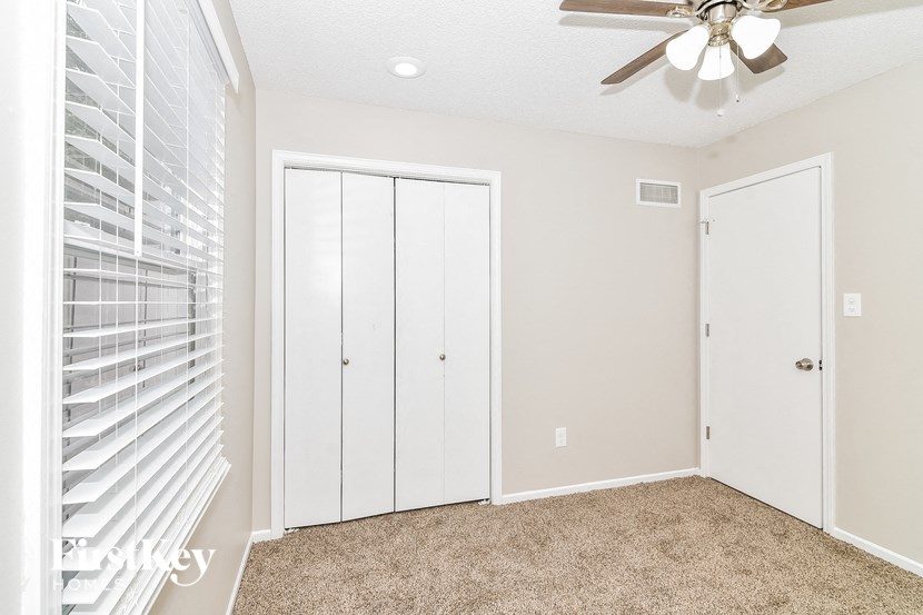 a bedroom with a ceiling fan and a closet
