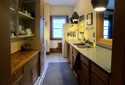 A kitchen with wooden cabinets and a checkered floor.