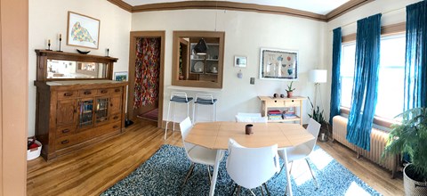 A dining room with a wooden table and chairs.
