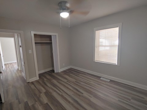 a living room with wooden floors and a ceiling fan