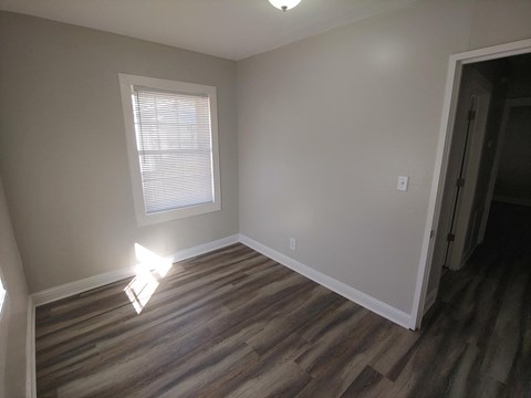 a living room with wooden floors and a window