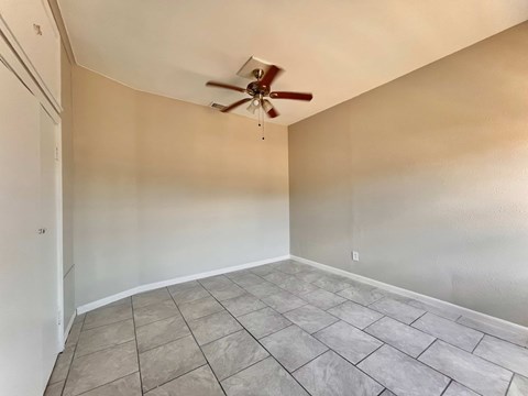 the living room has a ceiling fan and a tiled floor