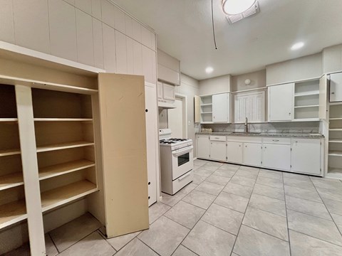 a kitchen with white cabinets and a stove and a counter top