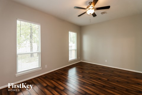 A room with wooden floors and a ceiling fan.