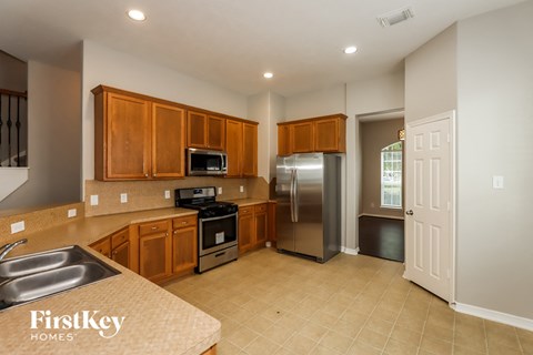 A kitchen with wooden cabinets and a stainless steel refrigerator.