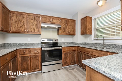 A kitchen with wooden cabinets and a stainless steel oven.