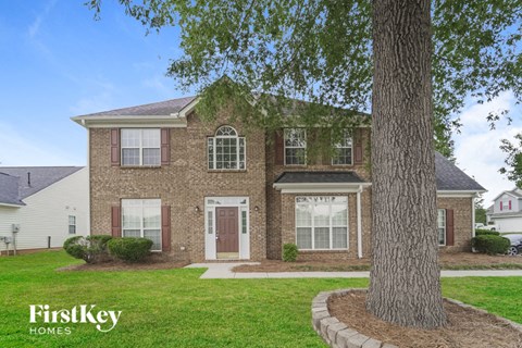 a brick house with a tree in front of it