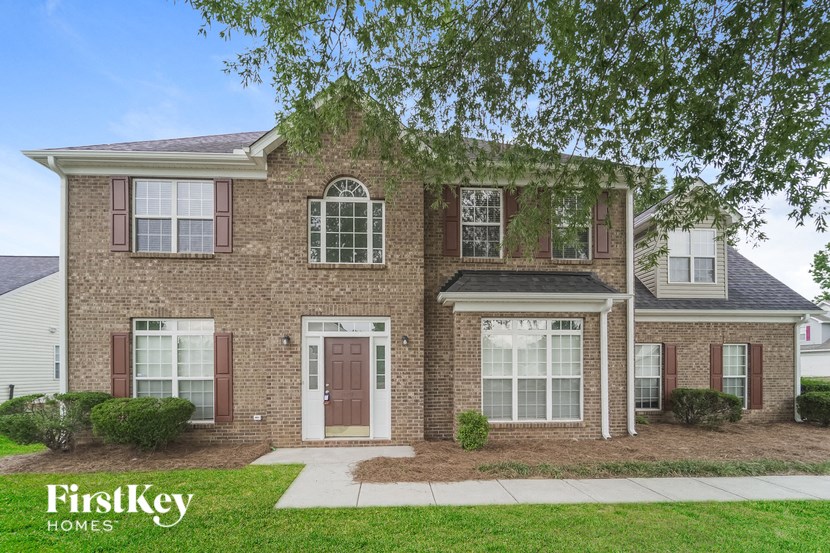 a brick house with a sidewalk in front of it