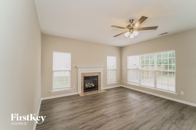 a living room with a fireplace and a ceiling fan