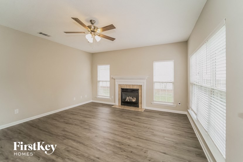 a living room with a fireplace and a ceiling fan