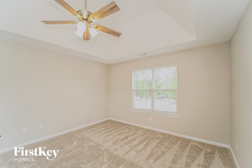 the living room of an empty home with a ceiling fan