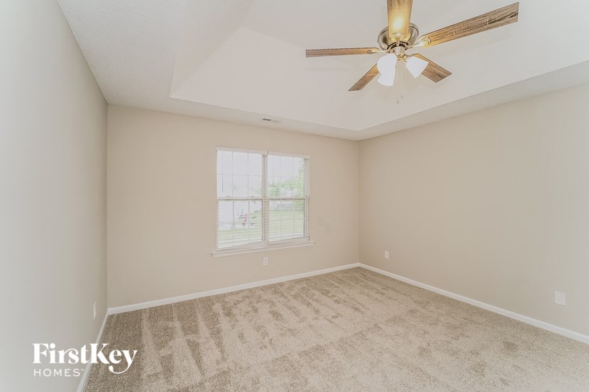 the living room of an empty home with a ceiling fan