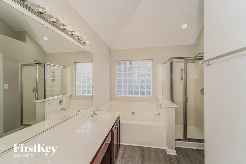 a bathroom with a large mirror and a sink and a shower