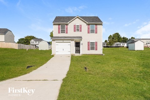 a white house with red shutters and a sidewalk in front of it