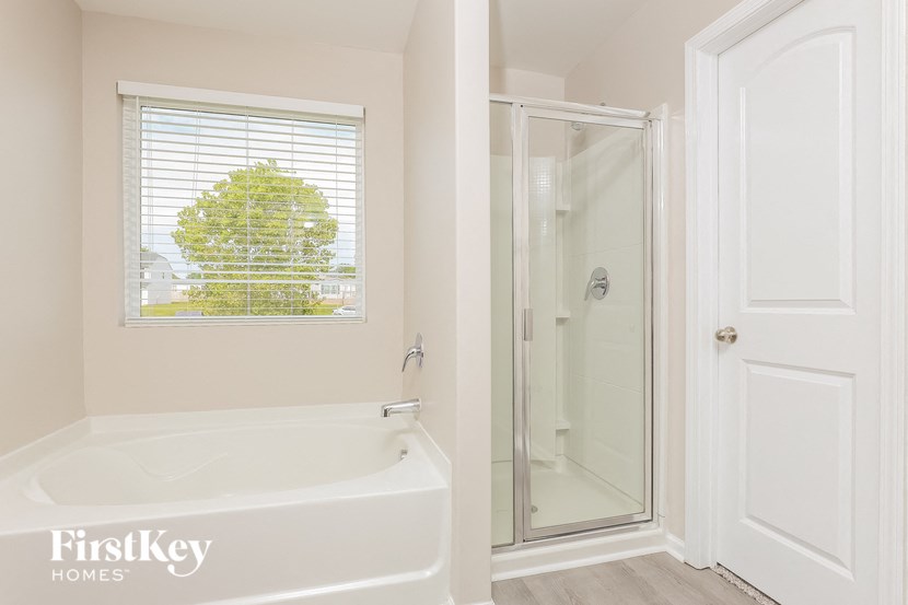 a bathroom with a tub and a shower and a window