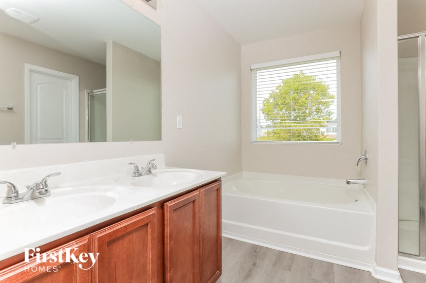 a bathroom with two sinks and a tub and a mirror