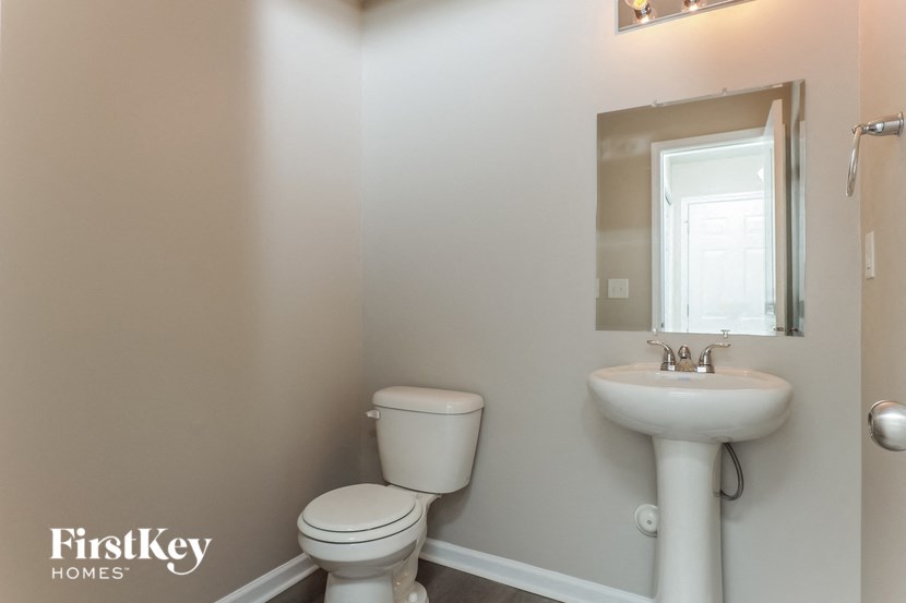 a bathroom with a toilet and a sink and a mirror