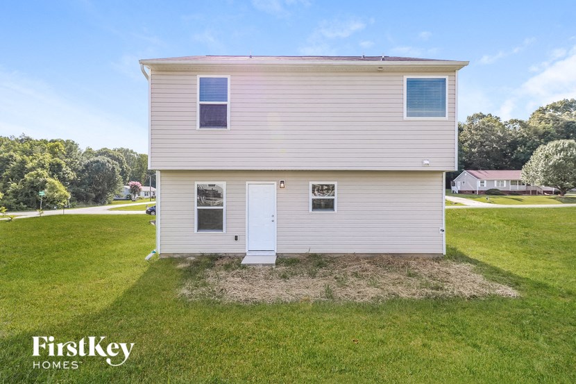 a small white house in the middle of a field