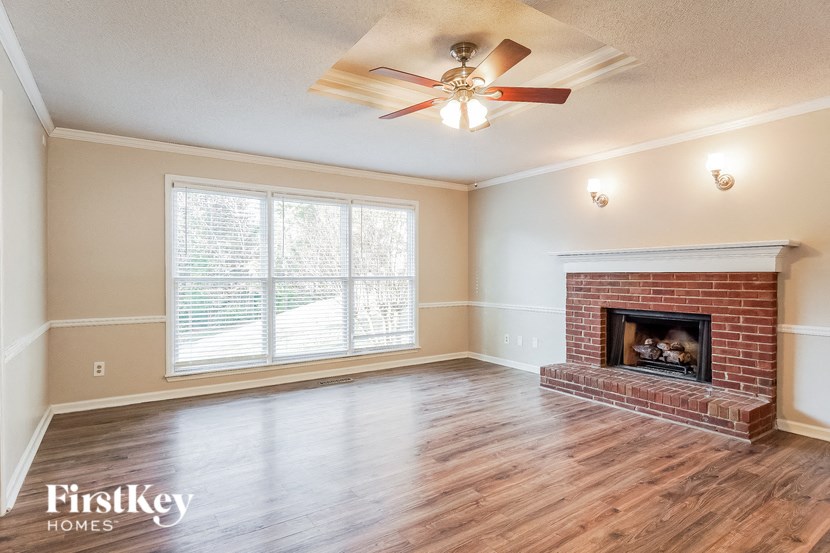A room with a fireplace and a ceiling fan.
