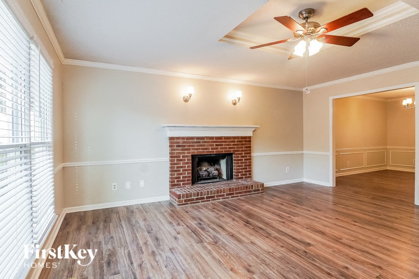 A room with a fireplace and a ceiling fan.
