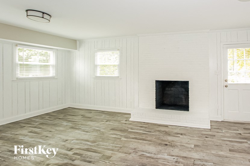 a living room with a fireplace and a wooden floor