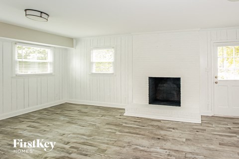 a living room with a fireplace and a wooden floor
