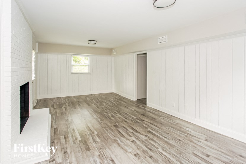 an empty living room with wood floors and a fireplace
