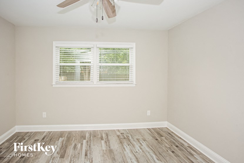a empty room with a window and a ceiling fan