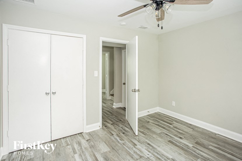 a bedroom with a closet and a ceiling fan