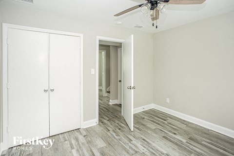 a bedroom with a closet and a ceiling fan