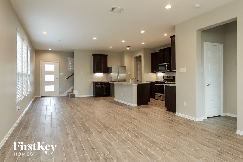 an empty kitchen and living room with a wood floor